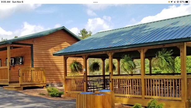 A wooden cabin with a porch and a covered seating area. - Boho shabby chic shack In beautiful resort (Newland)