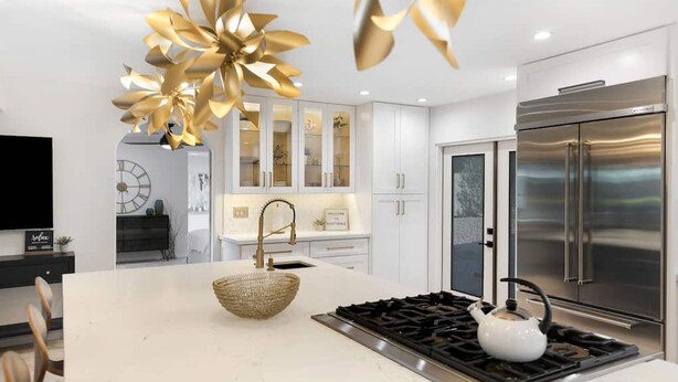 A modern kitchen with a central island, stainless steel appliances, and a decorative chandelier. - Stunning Vacation Dream Home W/backyard Paradise! (Scottsdale)