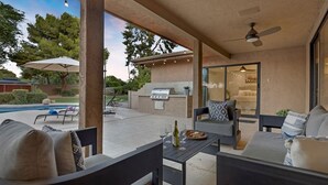An outdoor patio area with a pool, a barbecue grill, and seating furniture. - Stunning Vacation Dream Home W/backyard Paradise! (Scottsdale)