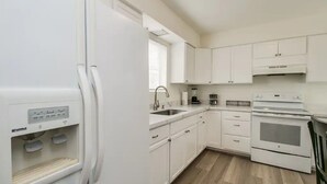 A modern kitchen with white cabinets, a built-in oven, and a refrigerator. - Remodeled 2 Bdrm w/ Yard in Old Town Scottsdale! (Scottsdale)