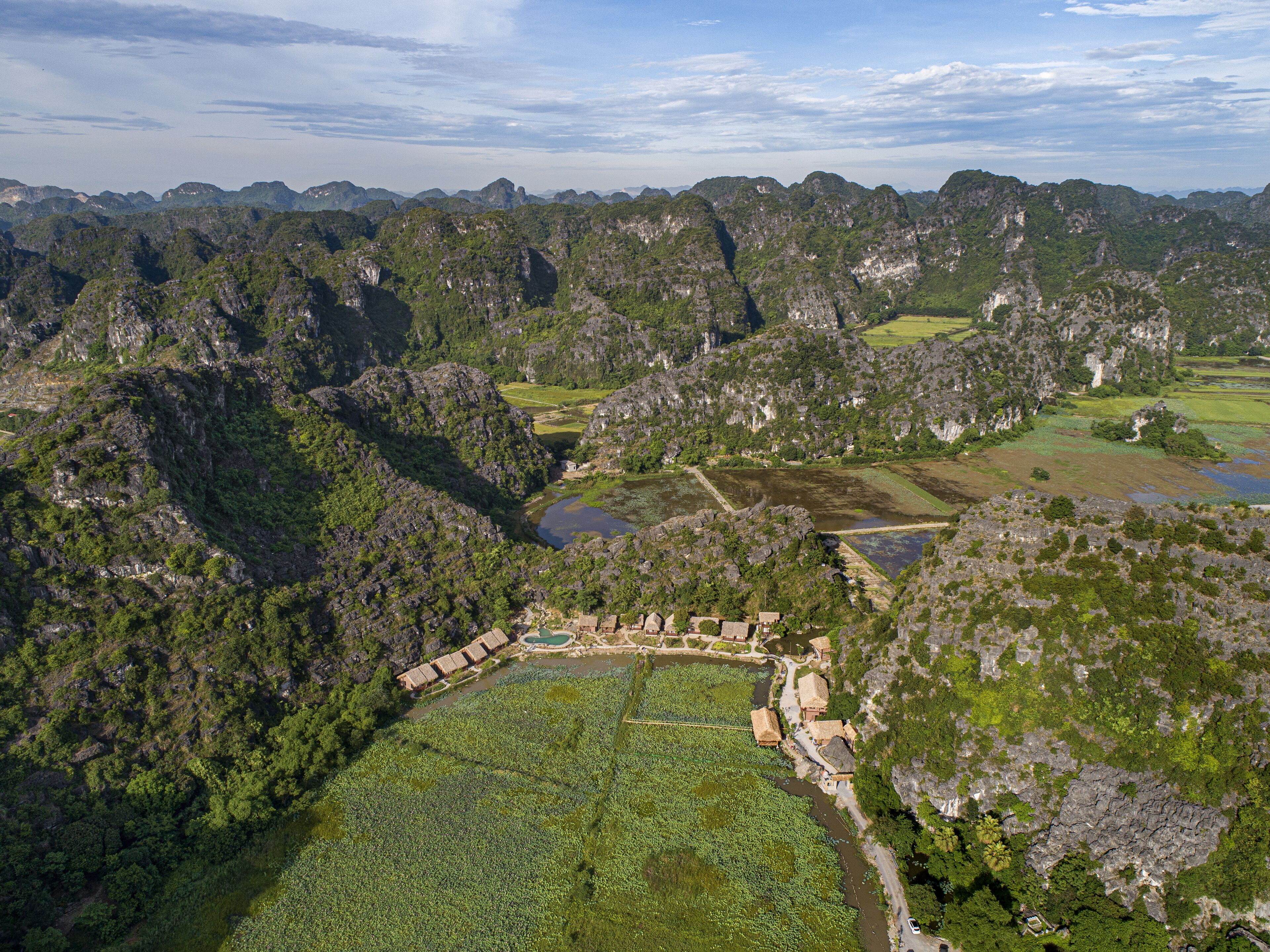 An aerial view of a mountainous area with terraced fields and traditional buildings.