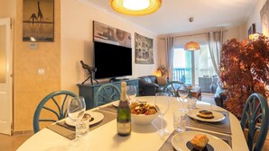 A dining area with a table set for two, a bottle of wine, and a bowl of food. - Puerta del mar 2 Mijas, Mijas Costa, Spain (Mijas Costa)