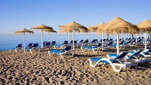 A beach with rows of sun loungers and thatched umbrellas. - Puerta del mar 2 Mijas, Mijas Costa, Spain (Mijas Costa)