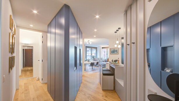 Un intérieur moderne avec un plancher en bois, un coin cuisine et un espace salon.