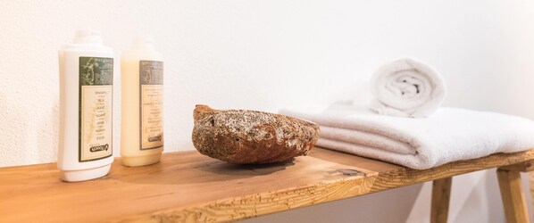Una repisa de madera con dos botellas de loción y una piedra texturizada.