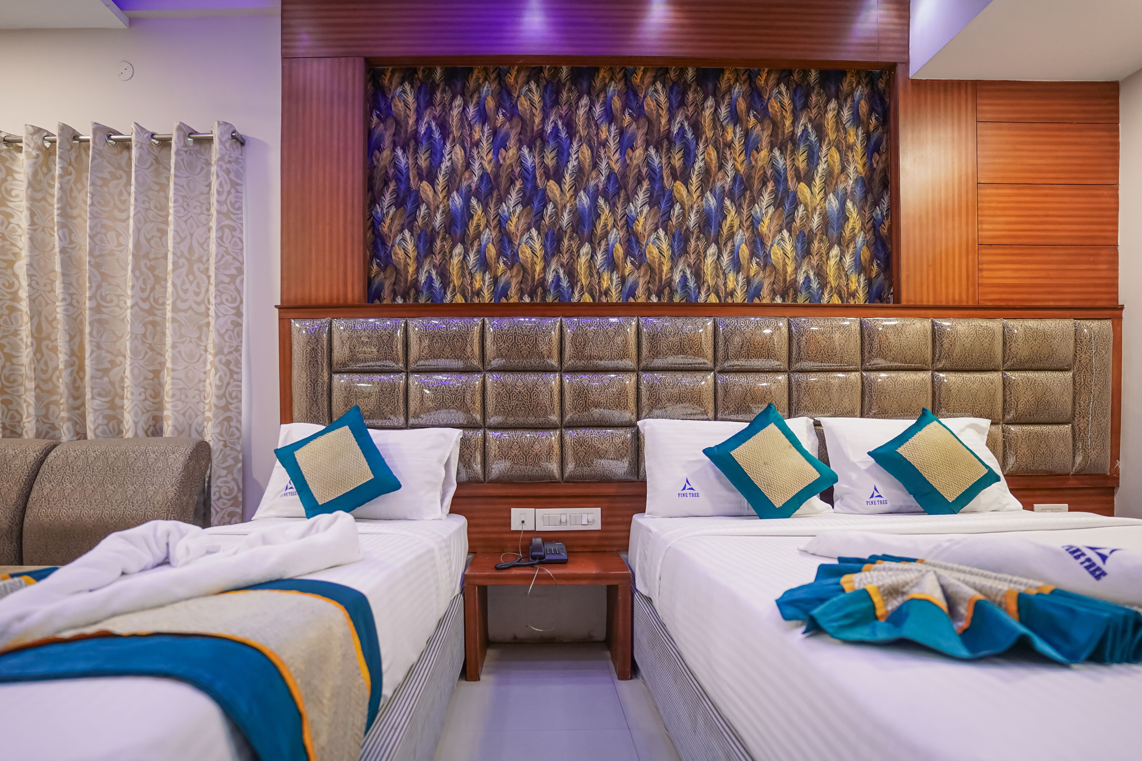 Una habitación de hotel con una cama grande, dos mesitas de noche y un panel decorativo en la pared.
