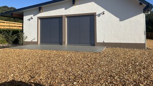Ein modernes Gebäude mit zwei großen Garagentoren, einem flachen Dach und einer Schotterauffahrt.
