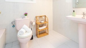 Une salle de bain moderne avec des toilettes, une étagère en bois, un lavabo et un miroir.