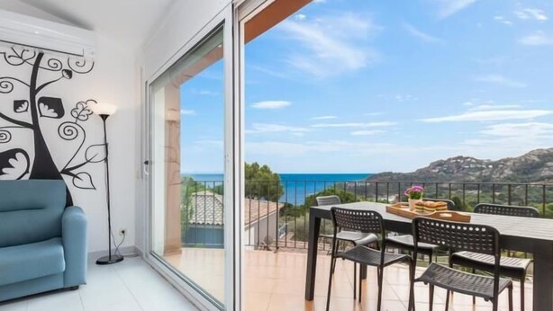 Un balcon avec une table et des chaises, un canapé et un mur décoratif.