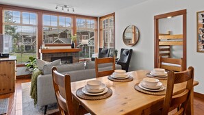 A dining area with a wooden table set for four, surrounded by wooden chairs. - Outdoor Adventure at Sun Peaks 33 (Sun Peaks)
