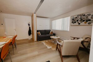 A modern living room with a sofa, a dining table with chairs, a small round table, and a cowhide rug. - Top-notch comforts in a rural setting in Woody Creek on the River/close to Aspen (Snowmass)