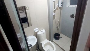 A small bathroom with a toilet, bidet, and shower. - Cosmo Hotel Espana Near Ust (Manila)