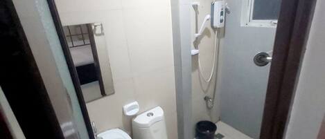 Un baño pequeño con inodoro, bidé y ducha.