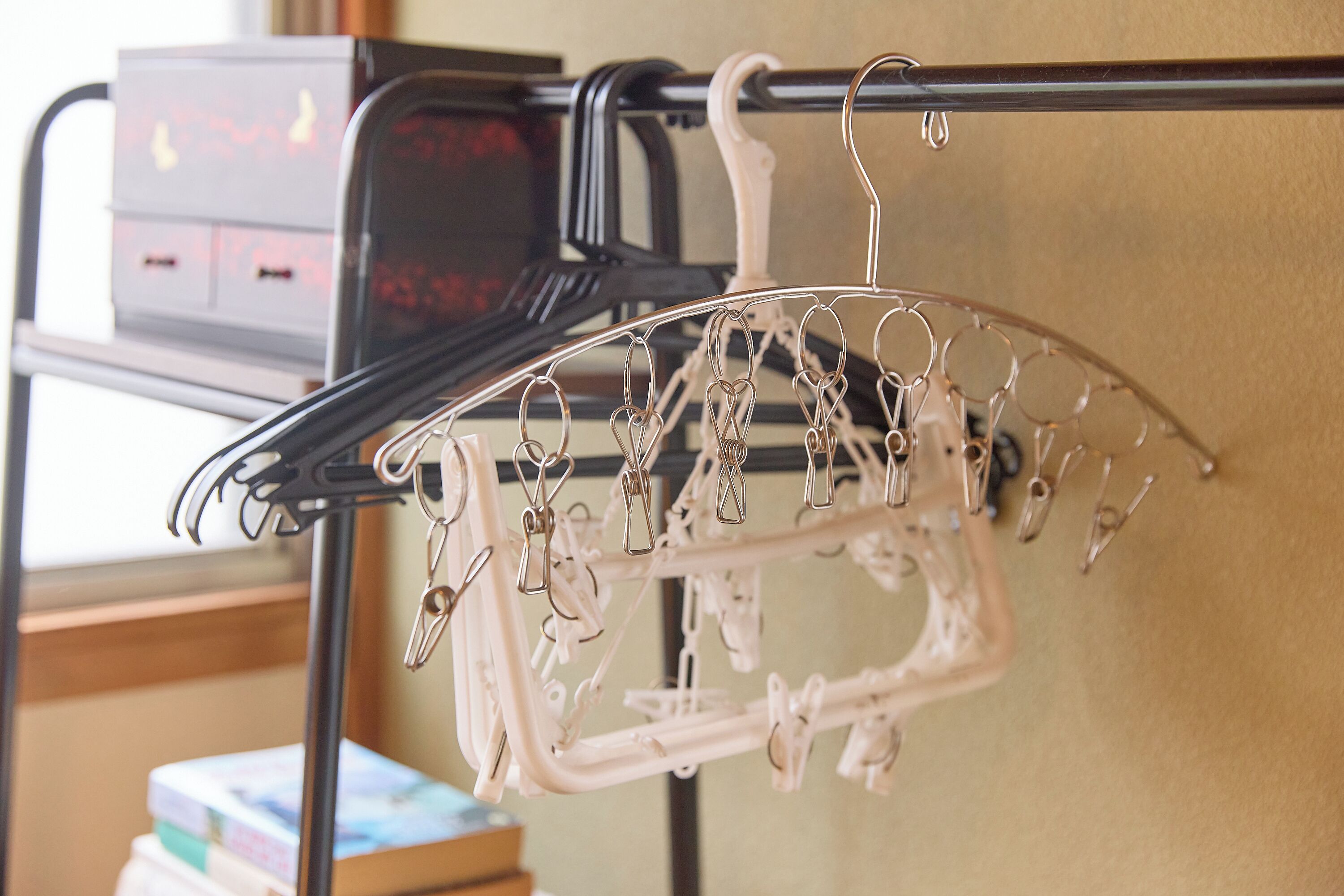 A metal rack with multiple hooks and a white plastic drying rack.