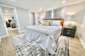 A modern bedroom with a large bed, a bedside table, and a nightstand.