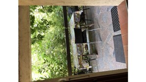 A patio area with a table and chairs, surrounded by greenery. - Ground floor in villa (L'Île-Rousse)