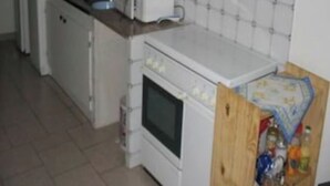 A compact kitchen with a refrigerator, microwave, and oven. - Ground floor in villa (L'Île-Rousse)
