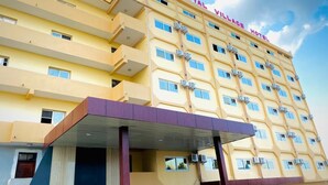 A multi-story hotel with a yellow facade and balconies. - Royal Village Hotel Dar Es Salaam (Dar es Salaam)