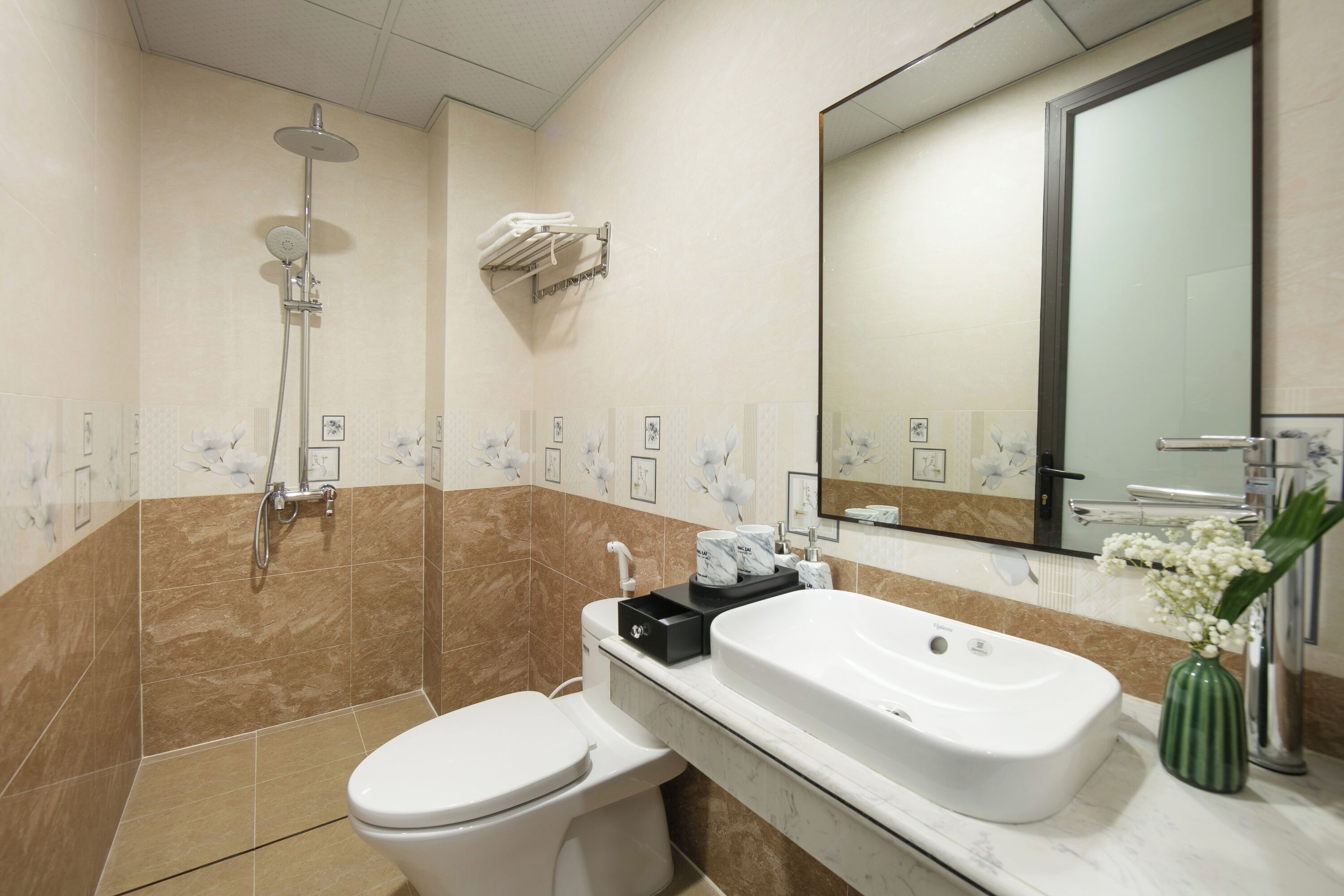 A modern bathroom with a shower, toilet, and sink.