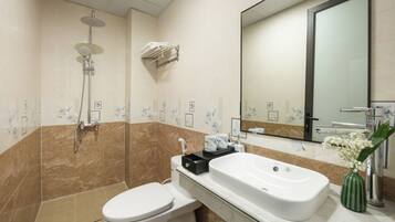 A modern bathroom with a shower, toilet, and sink.