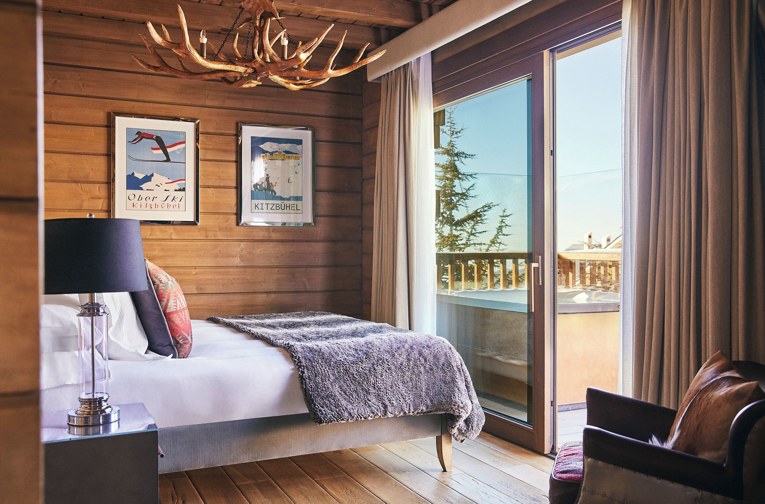 Una habitación con paneles de madera, una cama, una lámpara y dos cuadros en la pared.