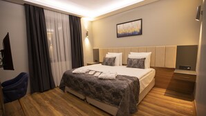 Une chambre d’hôtel moderne avec un grand lit, un bureau et une chaise.