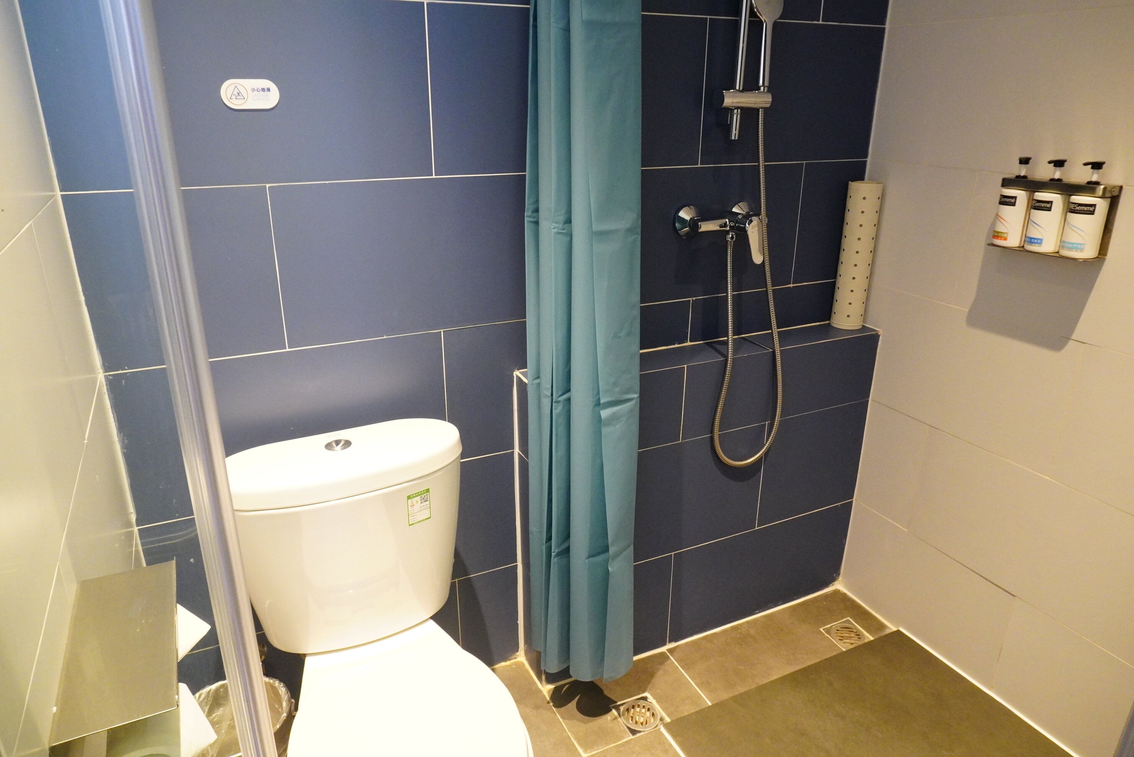 Ein kleines Badezimmer mit Toilette, Dusche und Handtuchhalter.