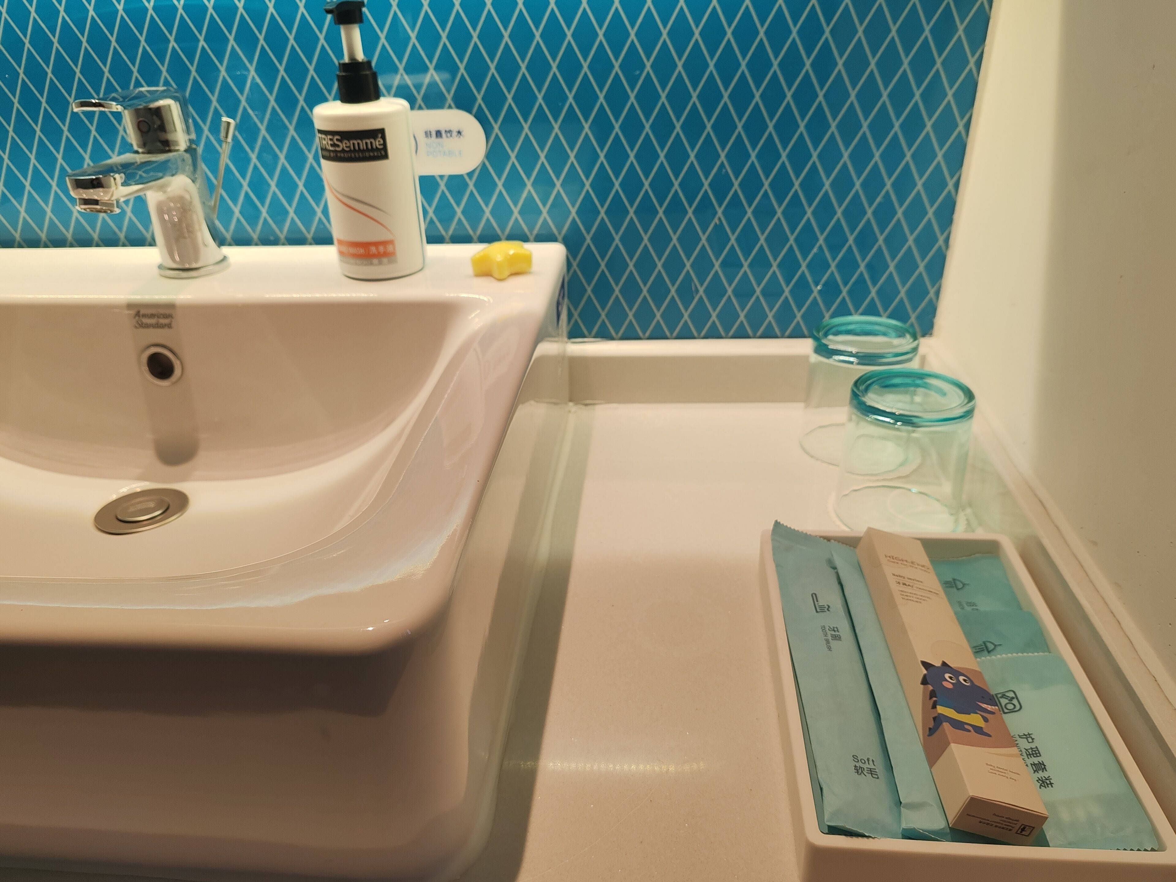 A bathroom with a white sink, a bottle of hand soap, and a tissue box.