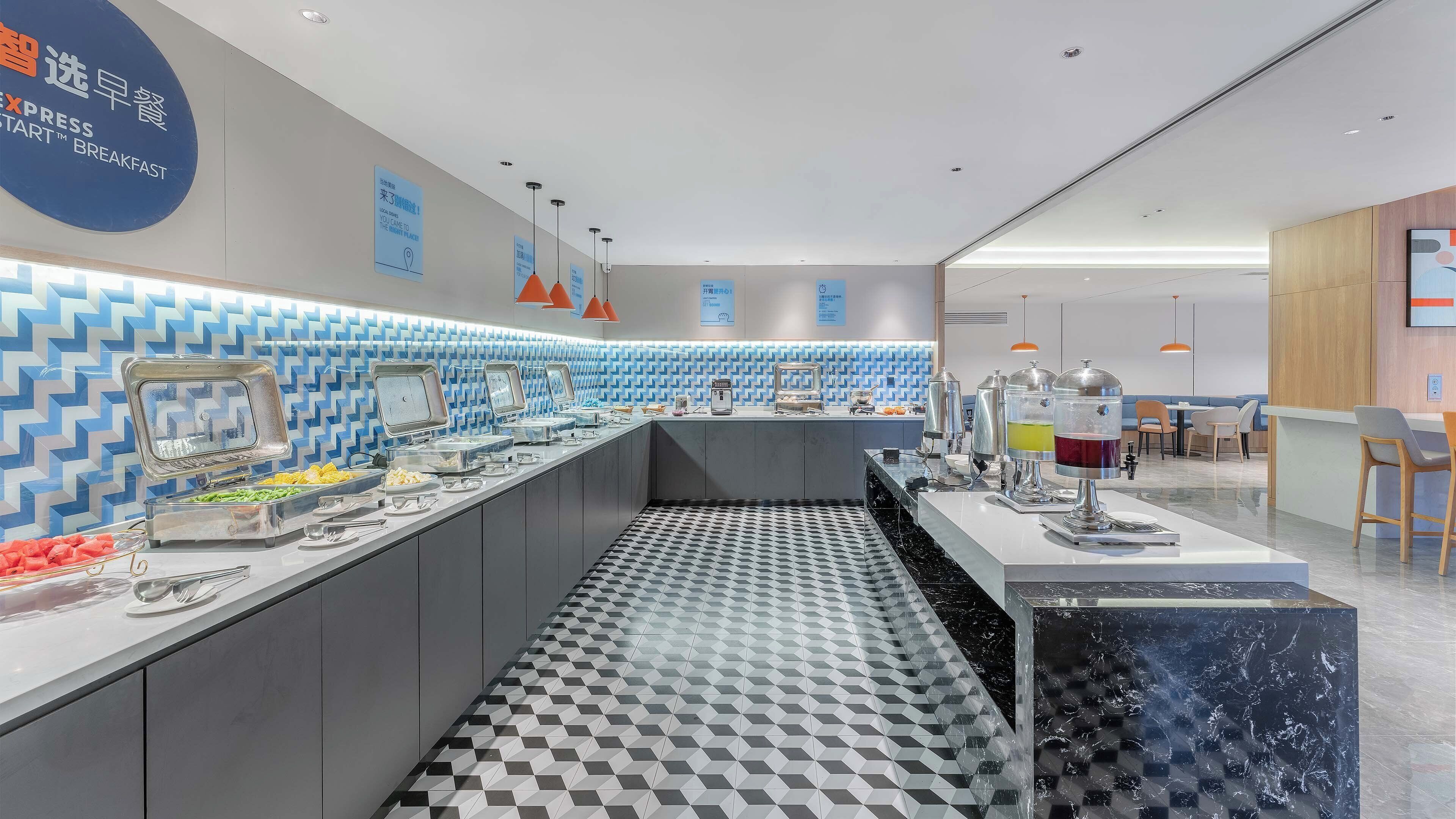 A modern breakfast area with buffet counters, a patterned floor, and a seating area with tables and chairs.