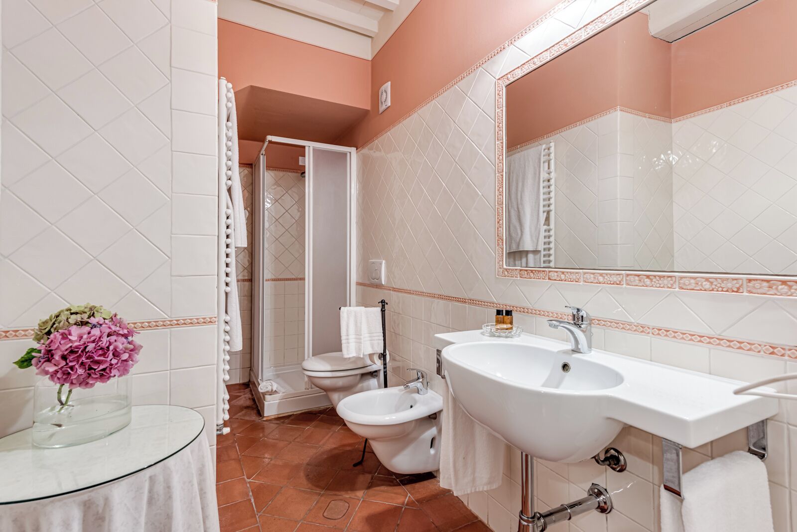 Un baño con un lavabo de vidrio, un inodoro y una ducha.