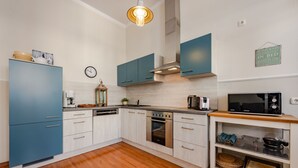 Una cocina moderna con gabinetes color turquesa, un microondas y una encimera de madera.