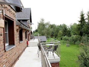 A brick building with a balcony, outdoor seating, and a garden. - Vacation apartment Am Obstbaum "Apple" (Golßen OT Zützen)