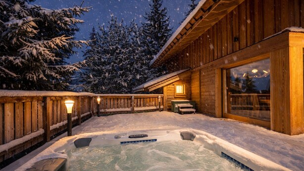 A wooden cabin with a hot tub surrounded by snow-covered trees. - Luxurious Chalet in Courchevel-La Tania: Sleeps 12, Ski-in/Ski-out, Jacuzzi, Sauna & Home Cinema (La Tania)