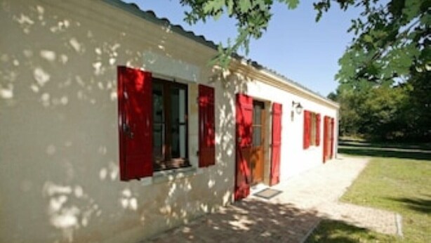 A white building with red shutters and a brick pathway leading to the entrance. - Lovely rural house at Carcans close to lakes and surfing beaches (Carcans)