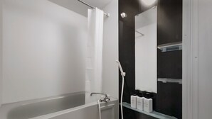 Un baño moderno con bañera, cabezal de ducha manual y espejo.