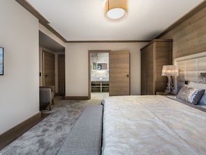 Relax in this serene bedroom with a large bed, bedside table, and walk-in closet.