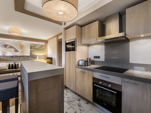 Enjoy cooking in this kitchen with a central island, oven, and large range hood.
