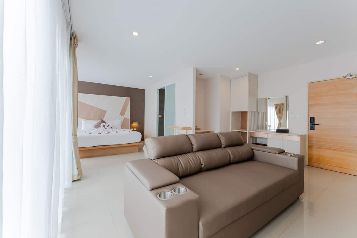 Een moderne hotelkamer met een groot bed, een bank, een bureau en een kledingkast.
