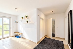Ein modernes Interieur mit einer Bank, Topfpflanzen und einem Duschbereich.