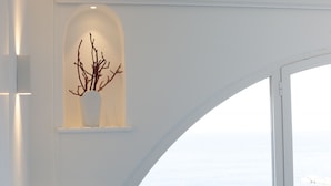 A white interior with a curved window overlooking a body of water.