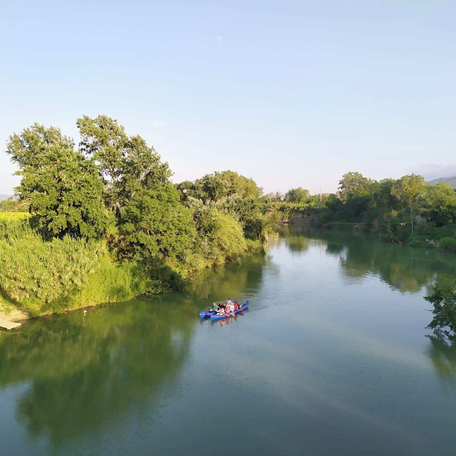 Ein ruhiger Fluss mit einem kleinen Boot, das Passagiere befördert.