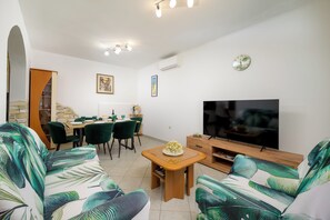 A living room with a sofa set, a dining table with chairs, a TV, and artwork on the walls. - House Maria (Istria - Bokordići) (Bokordići)