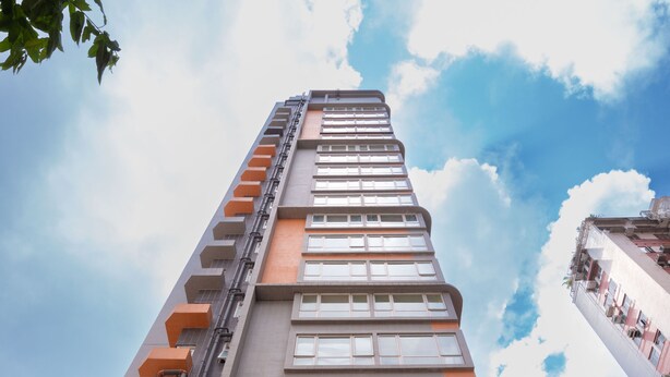 A tall building with multiple floors, large windows, and a mix of brick and glass facades. - China Rich Hotel (Hong Kong)