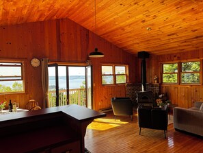 A wooden cabin interior with a kitchen, dining area, and a fireplace. - Magnificent location with views of Bras d'Or Lake - Exclusive vacation home with 75 sqm (st. peters)