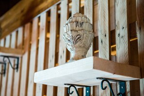 A white ceramic urn on a wooden shelf with metal brackets. - Trulli Nuova Aia Resort (Martina Franca)