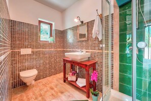 A bathroom with a toilet, sink, vanity, and shower area. - Pool Villa Abbazia Seaview (Opatija)