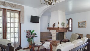 A living room with a fireplace, seating, and a television. - Costa Red Villa, Quarteira, Algarve (Semino)