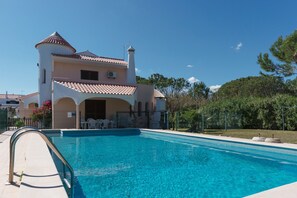 A two-story building with a swimming pool in front.
