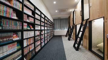 A library with bookshelves, a carpeted floor, and a wooden wall.