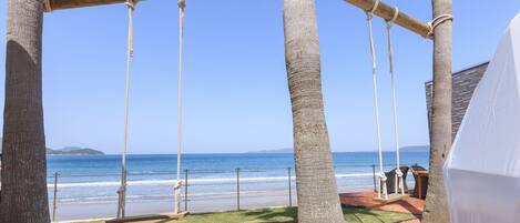 Vista de la playa con un columpio y una zona techada.